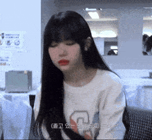 a girl with long black hair is wearing a white sweatshirt with the letter g on it