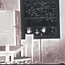 a blurry picture of a room with a chalkboard and a window .