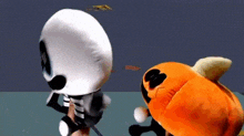 a skeleton and an orange stuffed animal are standing next to each other on a table .