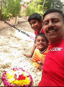 a man in a red shirt with the word mode on it poses with two children