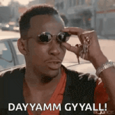 a man is wearing sunglasses and holding a bunch of keys .