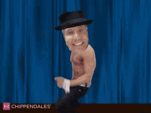 a man without a shirt is wearing a top hat and smiling in front of a blue curtain ..