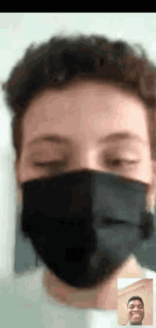 a man wearing a black face mask is on a video call