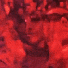 a close up of a woman 's face in a red light with a microphone .