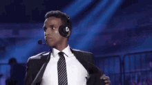a man in a suit and tie wearing headphones and a microphone .