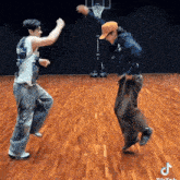 two men are dancing on a wooden floor in front of a basketball net .