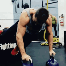 a man is lifting a kettlebell in a gym with a sign that says fighting