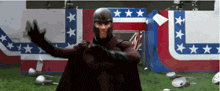 a man in a superhero costume is standing in front of a flag with stars on it