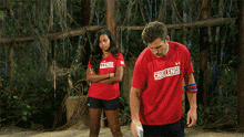 a group of people wearing challenge shirts stand around a skull