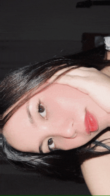 a close up of a woman with her hand on her face
