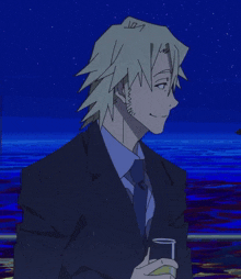 a man in a suit and tie holds a glass in front of a body of water