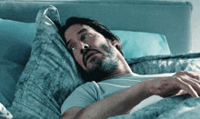 a man with a beard is laying in bed