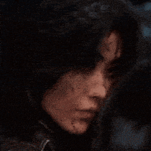 a close up of a woman 's face with a blurred background .