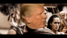 donald trump is standing in front of a group of people in a movie .