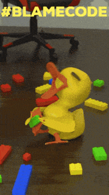 a yellow toy duck is surrounded by lego bricks and the words #blamecode