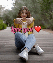 a woman is sitting on a wooden walkway with the words " love you " above her