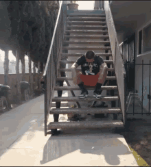 a man sitting on a set of stairs with a shirt that says arizona on it