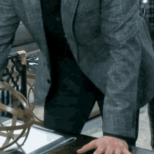 a man in a suit is standing in front of a desk