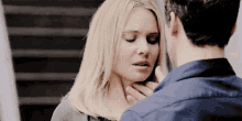 a man is touching a woman 's neck in a close up .