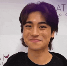 a young man is smiling in front of a sign that says academy