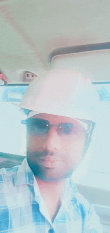 a man is wearing a hard hat and sunglasses