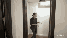 a woman is standing in a hallway with the words made in animatica on the bottom left