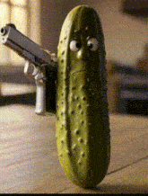a pickle is holding a gun with a sad face on it