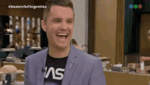 a man in a suit and nasa shirt is laughing
