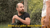 a man with a beard is holding a bottle with the words boon ci ci gider misin lutfen on the bottom