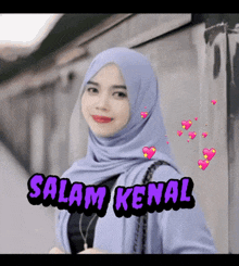 a woman wearing a purple hijab with the words salam kenal on it