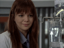 a woman in a lab coat stands in front of a bag of liquid