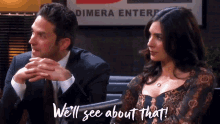 a man and a woman sitting in front of a sign that says dimera enterp