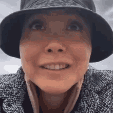 a close up of a woman wearing a hat and smiling