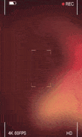 a phone screen shows a man 's face and says " rec " at the top
