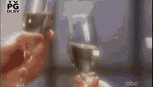 a person is holding two glasses of wine in their hands and making a toast .