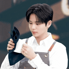 a man in an apron is holding a napkin in his hands