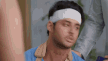 a man with a bandage on his head looks at the camera