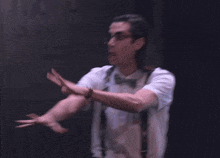 a woman in a white shirt and suspenders is running in the dark