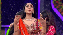 a woman in a red dress is standing next to another woman in a red dress .
