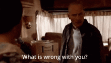 a man is standing in front of a box that says fragile on it and asking what is wrong with you .