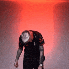 a man with a tattoo on his arm is wearing a adidas shirt