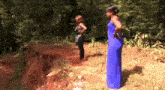 a woman in a blue dress is standing next to another woman in a black dress