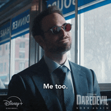 a man in a suit and tie says me too on a daredevil born again poster