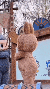 two stuffed animals are standing next to each other in front of a sign with a viking head on it