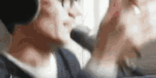 a man wearing headphones and a microphone is talking into a microphone .