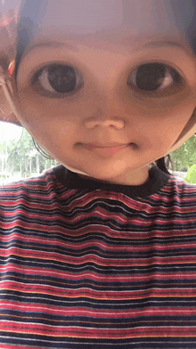 a close up of a child 's face with a striped shirt