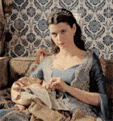 a woman wearing a tiara is holding a baby