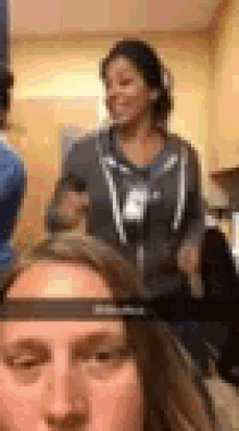 a group of people are standing around a woman 's head in a bathroom .