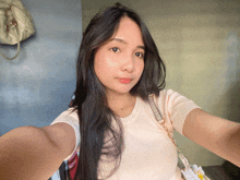 a woman taking a selfie with a purse hanging on the wall