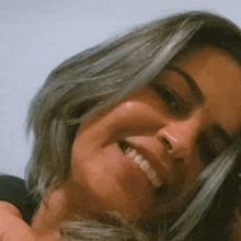 a close up of a woman 's face with a smile on her face .